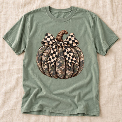 Sage green tee laid flat with a camo pumpkin topped by an oversized black and cream checkered bow