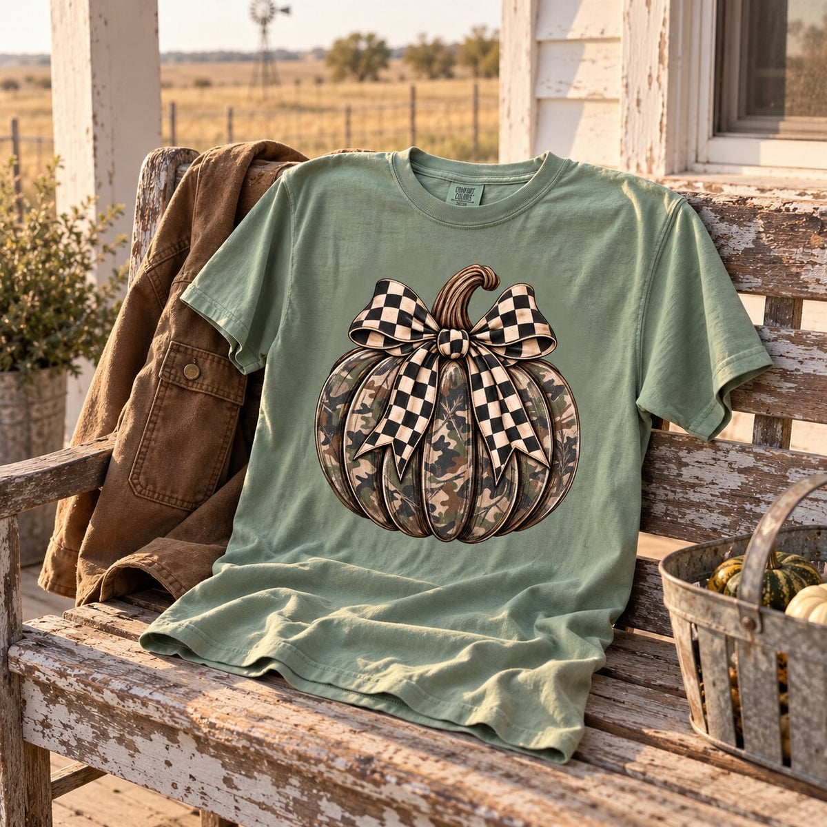 Camo pumpkin bow tee draped on a weathered porch bench beside a brown jacket and a basket
