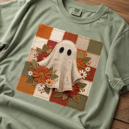 Close-up of the patchwork ghost graphic showing the stitched fabric texture, black button eyes, and surrounding fall florals on sage green cotton.